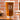 Pint glass on a table. The glass has an etched design centered. The design is of a square with swirly horizontal lines, and in the middle is the letter "D" in caps. Below the square is the name "DANIELS" in all caps. 